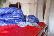 Sonja tied, gagged and hooded on bed with cuffs wearing a sexy grey shiny nylon rain pants and a blue down jacket (Pics)