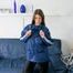 Katharina posing on a sofa wearing a blue/black shiny nylon rainwear (Pics)