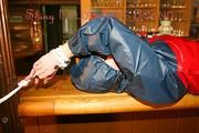 An archive girl tied and gagged on a bar wearing shiny nylon rainwear (Pics)