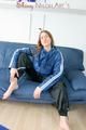 Katharina posing on a sofa wearing a blue/black shiny nylon rainwear (Pics)
