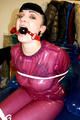 Jill tied and gagged in a semi-transparent purple PVC suit