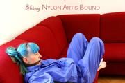 Mara tied and gagged on a red sofa wearing a sexy shiny lightblue rainwear (Pics)