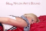 Pia tied and gagged on bed wearing a shiny darkblue nylon shorts with red stripes and white shirt (Pics)