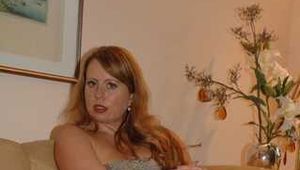 Chubby redhead Benita stripping out of her grey dress and stockings on couch