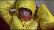 Sonja wearing a blue rain pants and a yellow PAMY down jacket while bonding herself an the sofa (Video)