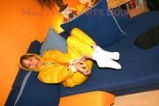 Archive girl tied and gagged on sofa wearing a shiny yellow rainwear (Pics)