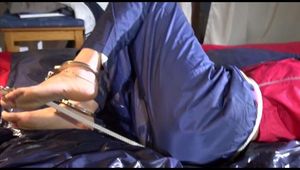 Sonja tied and gagged on bed with cuffs wearing a sexy rainwear combination (Video)