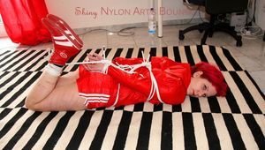 Marlin tied and gagged in red nylon shorts and red cagoule