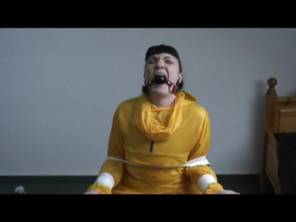 Jill Tied And Gagged On A Chair Wearing A Yellow Rainsuit And Coveres With An Yellow Raincoat With Two Hoods (Video)