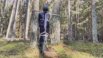 Sebastien breathplay tied up in a puffer jacket among the trees.