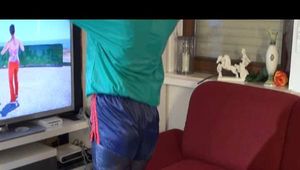 Mara wearing a blue shiny nylon shorts a black leggin and a grren rain jacket during her workout (Video)