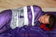 Alina tied, hodded and gagged on the floor in an purple/silver shiny PVC suit (Pics)