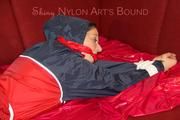 Lucy tied, gagged and hooded with ropes on a sofa wearing a sexy blue/red rainwear combination (Pics)