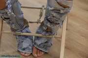 Hot jeans girl cuffed on a chair