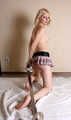 Topless barefoot Hannah, handcuffed and legcuffed with steel restraints, poses for the camera