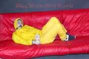 MARA ties, gagges and hoodes herself with cuffs and a ballgag on a sofa wearing sexy yellow rainwear (Pics)