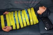 Katharina taped and gagged in a blue nylon rainsuit