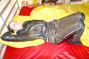 Lucy preparing her bed and enjoys it wearing sexy black rainwear (Pics)