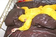 Stella tied and gagged on a bed wearing a supersexy yellow rainwear combination (Pics)