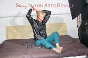 PIA ties and gagges herself with a bar and a cloth gag on a bed wearing a sexy green shiny nylon pants and a black rain jacket (Pics)