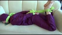 Mara tied and gagged on a sofa wearing a shiny purple rainwear combination (Video) 