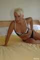 Short haired blonde MILF Claudia posing on bed