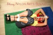 Stella tied and gagged on the floor wearing a shiny nylon rain pants (Pics)