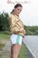 Watching out beautiful archive girl wearing a white shiny nylon shorts and a golden rain jacket posing outdoor (Pics)