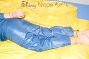 Alina wearing a sexy shiny rainwear suit in blue lolling on bed cuffed (Pics)