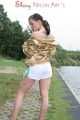 Watching out beautiful archive girl wearing a white shiny nylon shorts and a golden rain jacket posing outdoor (Pics)