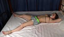Tapegagged topless barefoot Bianca in jeans shorts, tied on the bed with her legs wide-spread, wiggles helplessly