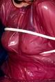 Jill tied and gagged in a semi-transparent purple PVC suit
