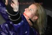 Watching sexy Pia wearing a sexy blue oldschool shiny nylon shorts and a rain jacket being tied and gagged on hands and feet on the ceiling lying on the floor (Pics)