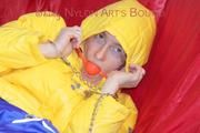 Sonja tied, gagged and hooded on a sofa wearing a sexy blue rain pants and a yellow downwear jacket (Pics)