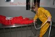 Watching Stella being tied and gagged with ropes and a ballgag on a operating table from Leonie both wearing sexy shiny nylon rainwear (Pics)