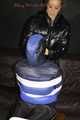 Sexy Mara wearing a black rain pants and a blue/black down jacket being tied, gagged and hooded with tape and clothgag (Pics)