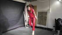 Marie in a custom video suspended in a shiny nylon Jumpsuit