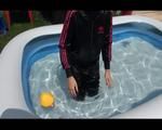 Mara wearing a shiny black/pink adidas training suit playing with water in the pool (Video)
