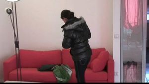 Enni with black shiny nylon shorts and rain pants and a rain jacket over naked skin smoking a cigarette (Video)