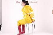 Jill tied and gagged in a shiny yellow rainsuit and rubber boots