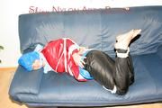 Jill tied, gagged and hooded on the sofa wearing a sexy black shiny nylon pants and two rain jackets (Pics)