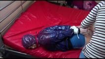 Jill tied, gagged and hooded on bed wearing oldschool shiny nylon shorts and a shiny rain jacket (Video)