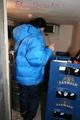 Jill posing in a cooling room wearing a shiny nylon rainpants and a down jacket (Pics)