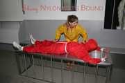 Watching Stella being tied and gagged with ropes and a ballgag on a operating table from Leonie both wearing sexy shiny nylon rainwear (Pics)