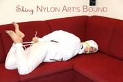 Pia tied and gagged on a sofa wearing a shiny white rain combination (Pics)