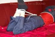 Lucy tied, gagged and hooded with ropes on a sofa wearing a sexy blue/red rainwear combination (Pics)