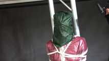 Aiyana in a shiny nylon red rainsuit and a see through PVC Rainjacket, tied gagged, hooded and vibed