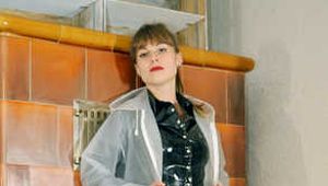 Miss Clara in einer sexy Lackhose und Lackblouse zieht einen transparenten Regenmantel an