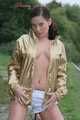 Watching out beautiful archive girl wearing a white shiny nylon shorts and a golden rain jacket posing outdoor (Pics)