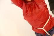 Jill tied and gagged on a stairway wearing a sexy blue shiny nylon shorts and a red rain jacket (Pics)